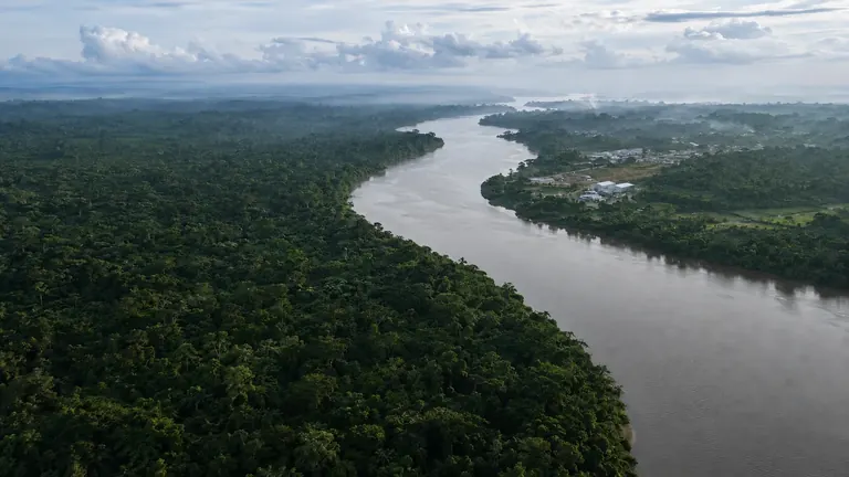 Vue aérienne d’un fleuve traversant la forêt guyanaise au lever du jour